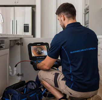 Plumber clearing a blocked toilet in a Burwood bathroom